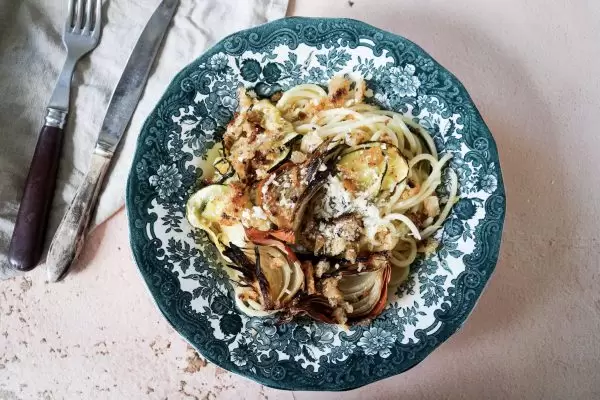 Pasta met geroosterde ui en courgette met broodkruim